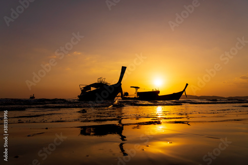 Traditional long-tail boat on the beach in Thailand at sunset © Netfalls