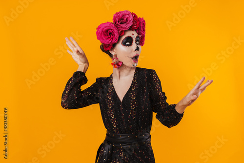 Photo of girl in halloween makeup and flower wreath dancing on camera