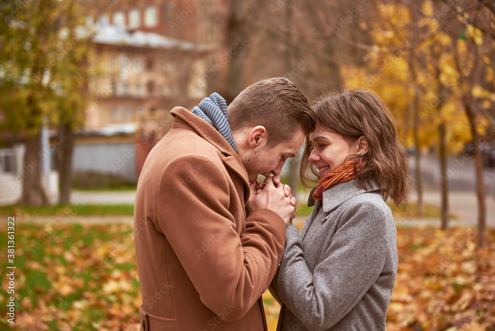 Fototapeta premium Young beautiful couple walking and hugging in the autumn park 