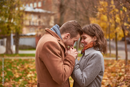 Young beautiful couple walking and hugging in the autumn park 