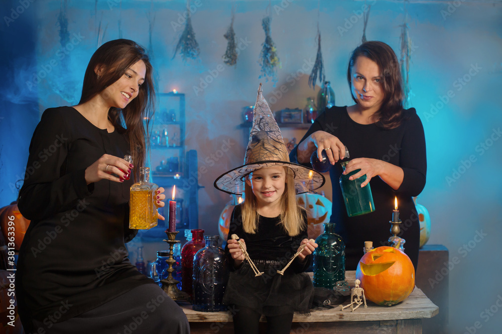family of witches with potions and Halloween pumpkins at home family of witches with potions and Halloween pumpkins at home