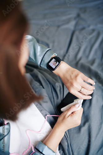 Sick young woman video calling her doctor via application on smartwatch
