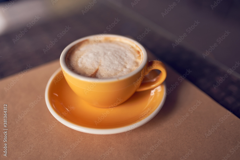 Cappuccino in the beautiful yellow ceramic cup. Beautiful foam and ceramic cup