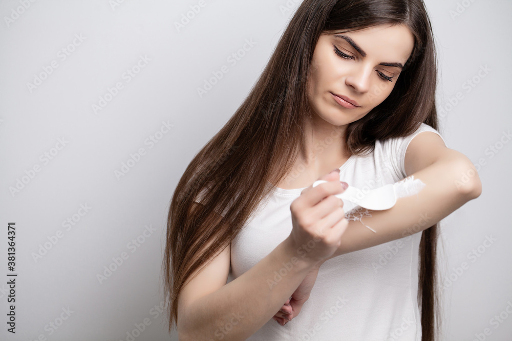 Woman applies hair removal cream on her hand Woman applies hair removal cream on her hand
