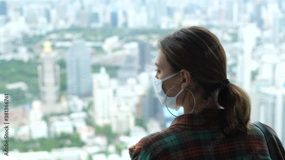 Caucasian woman traveller on high floor in bangkok wearing face medical mask Caucasian woman traveller on high floor in bangkok wearing face medical mask