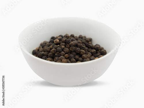 Black pepper, herbs, spices in a white bowl.