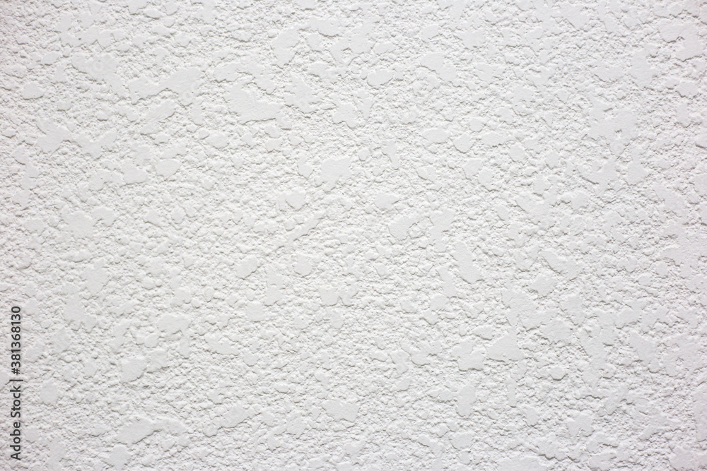 Wall with white textured plaster. Plaster in the form of blots on the wall Wall with white textured plaster. Plaster in the form of blots on the wall
