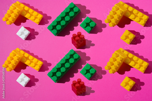 A pattern of green  white  red and yellow constructor details on a pink background