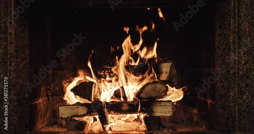 Slow motion of Fireplace burning. Warm cozy fire in a brick fireplace close up. Cozy winter relax background. Christmas mood. Filmed in RAW 120fps 4k DCi.	