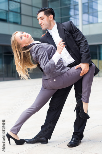 Businesswoman with her collegue are dancing tango outdoor near office.