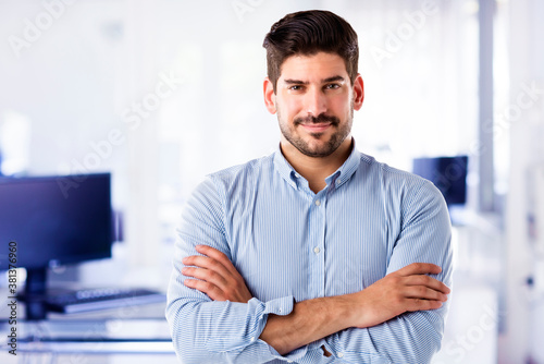 Confident businessman close-up portrait while standing at the office