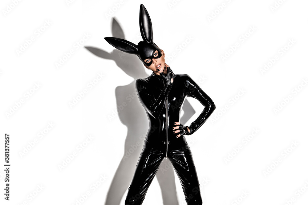 Halloween sexy girl in bunny costume. Sexy blonde beautiful woman posing in  latex costume and black bunny mask on white background. Hallooween concept.  Stock Photo | Adobe Stock