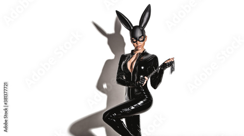 Halloween sexy girl in bunny costume. Sexy blonde beautiful woman posing in latex costume and black bunny mask on white background. Hallooween concept.