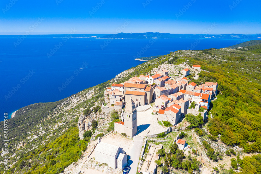 Aerial view of small historical town of Lubenice on the high cliff, Cres island in Croatia, Adriatic sea in background