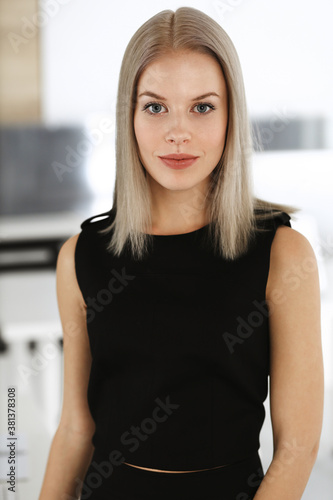 Young blond businesswoman is standing straight in modern office. Business people concept. Black dress do suits to her much at this portrait Free Download Young blond businesswoman is standing straight in modern office. Business people concept. Black dress do suits to her much at this portrait - GFXLoad