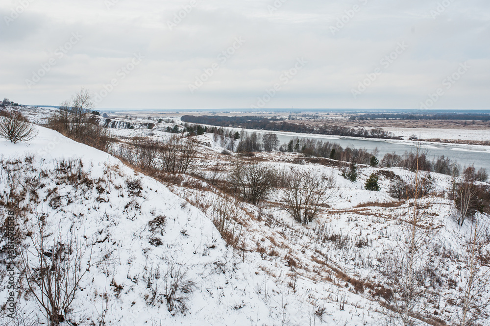 Winter monochrome landscape: white snow field and river