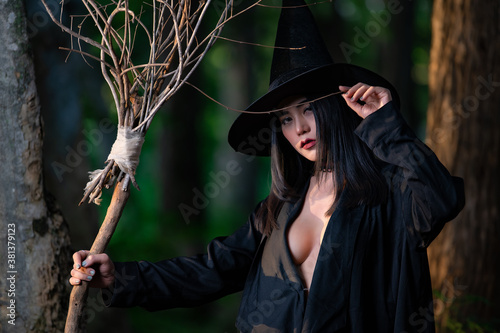 Slika na platnu Portrait of beautiful asian sexy woman wear black witch costume with broom,Hallo