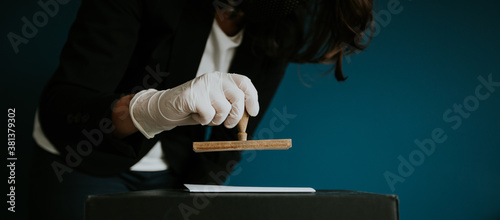 Close-up of voter with protection gloves putting stamp on the voting card during cobid19 pandemics. photo