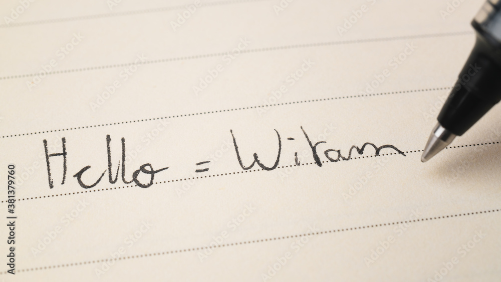 Obraz premium Beginner Polish language learner writing Hello word Witam for homework on a notebook