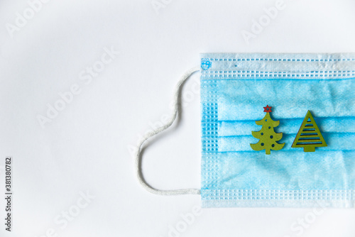 Christmas tree toys lie on a disposable medical mask on a white background with a place to insert text