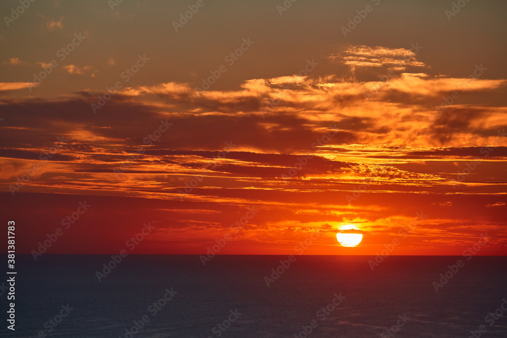 Sunset over ocean and cloudy sky. Golden hour and panoramic landscape idea. Virgin nature and evening seascape concept