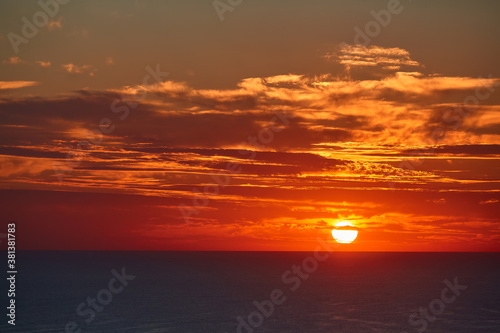 Sunset over ocean and cloudy sky. Golden hour and panoramic landscape idea. Virgin nature and evening seascape concept