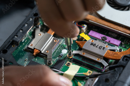 Close-up photo of an electrician repairing the computer's circuit