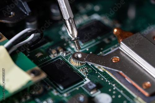Close-up photo of an electrician repairing the computer's circuit