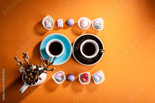 Overhead view of two cups of coffee and candies