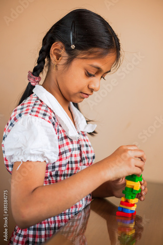 Cute Indian kid playing with puzzle toys.