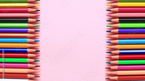 Stop the mish animation of the movement of colored pencils on a pink background photo
