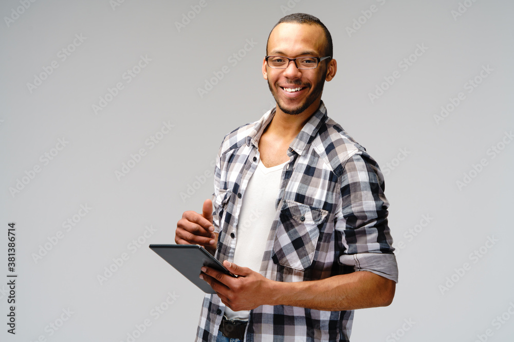 Portrait of a young african american man wearing green t-shirt holding tablet pc pad Portrait of a young african american man wearing green t-shirt holding tablet pc pad