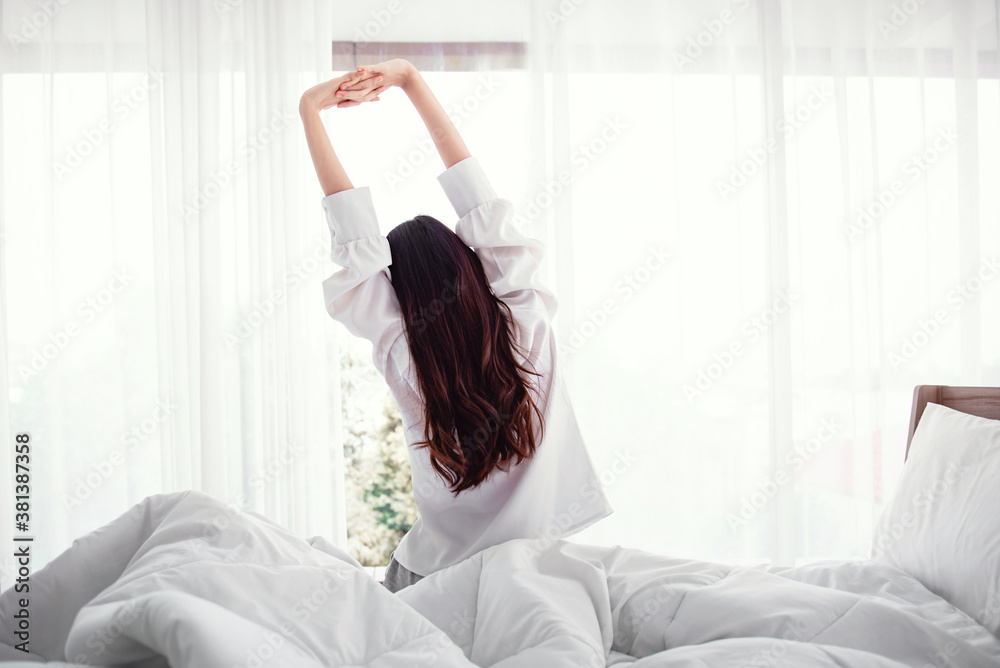 Woman stretching hands in bed after wake up in the morning, Concept of a new day and joyful weekend. Woman stretching hands in bed after wake up in the morning, Concept of a new day and joyful weekend.