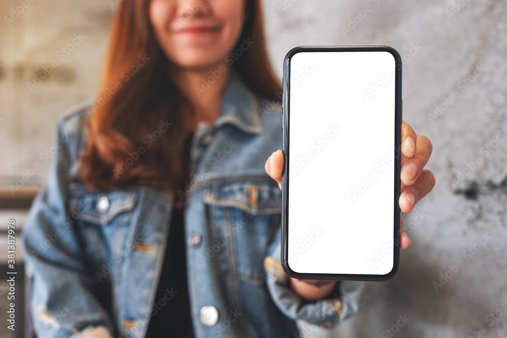 Mockup image of a beautiful asian woman holding and showing a mobile phone with blank white screen