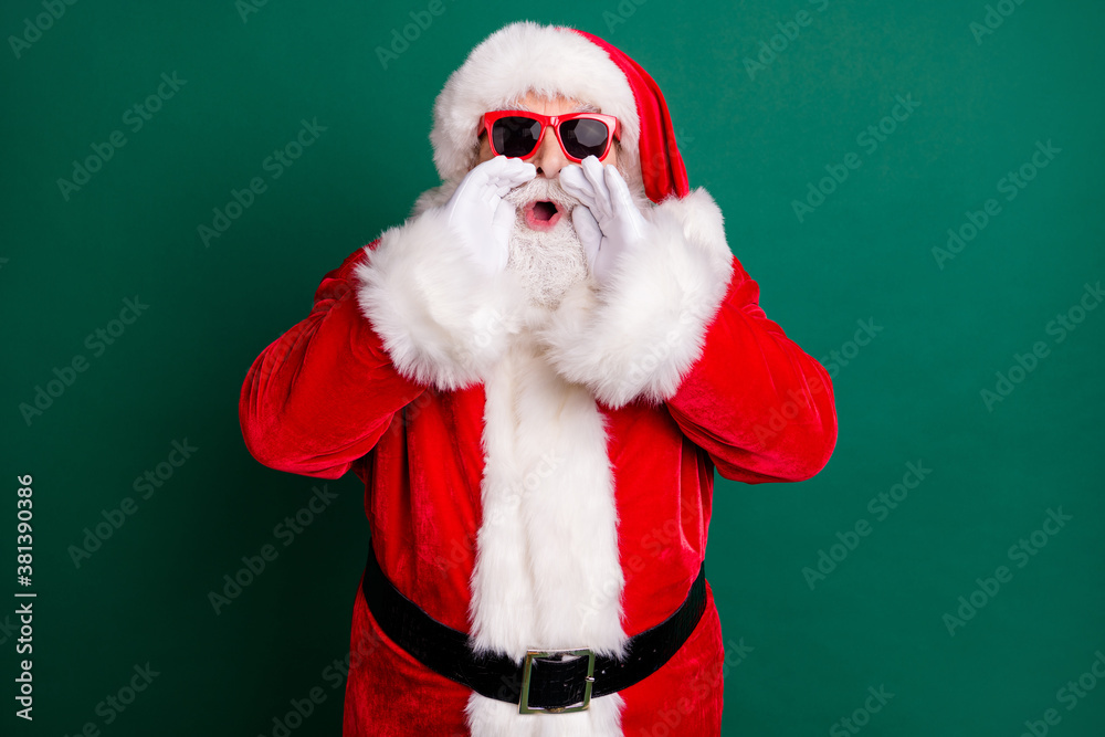 Naklejka premium Photo of pensioner grandpa white beard hands open mouth yelling promoting newyear shop wear red santa x-mas costume coat gloves sunglass belt headwear isolated green color background