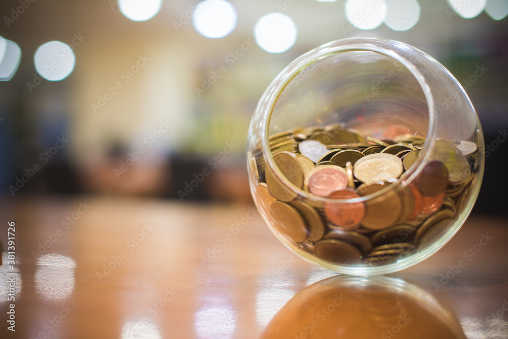 Money coins Thai baht in a round glass jar with Bokeh background. Banking, Finance and Saving money concept.