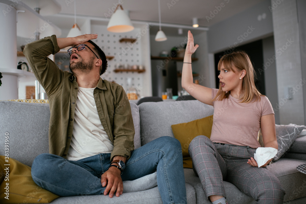 Boyfriend and girlfriend are arguing on the couch. Angry woman is yelling at her boyfriend. Boyfriend and girlfriend are arguing on the couch. Angry woman is yelling at her boyfriend.