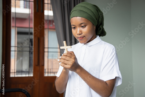 Christian African black woman cancer patient recovering from sickness, praying to God with holy cross, concept of cancer awareness related with Christianity © 9nong