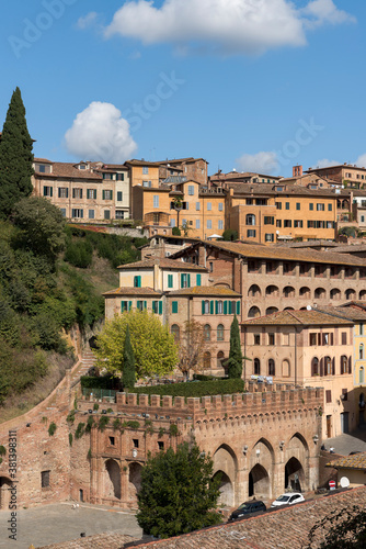 View of old medieval houses on a steep hill of Siena, Italy
