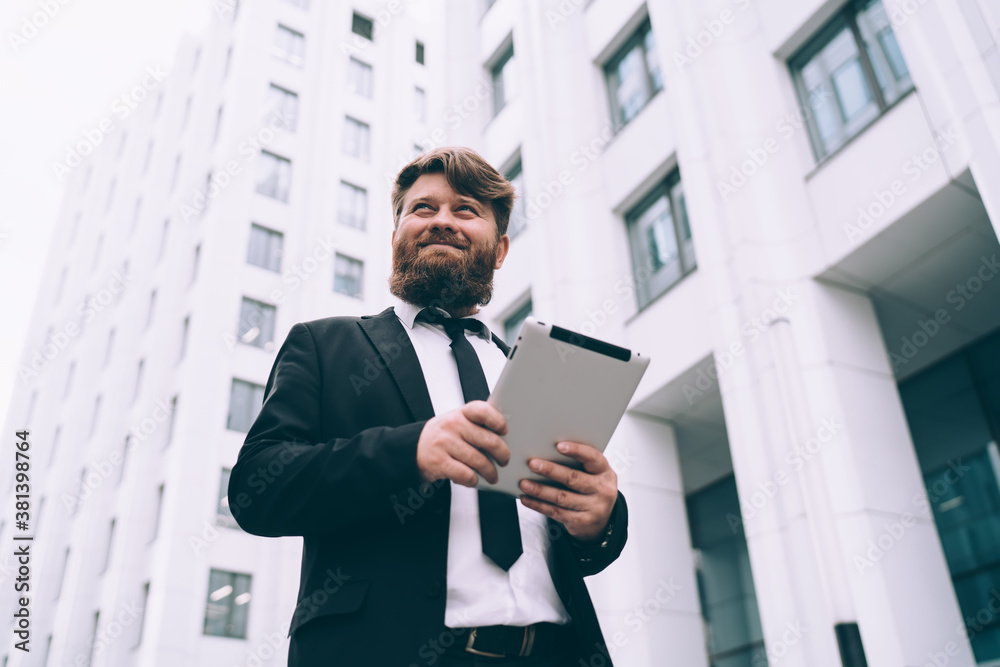 Positive businessman using tablet on street Positive businessman using tablet on street