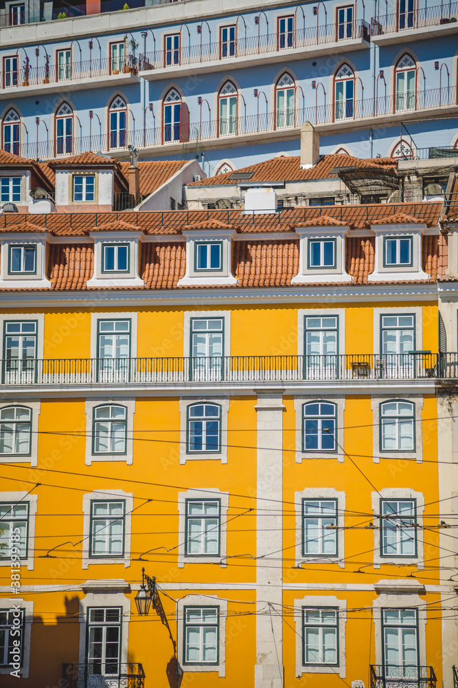 large yellow house with symmetrical windows and balconies. street architecture