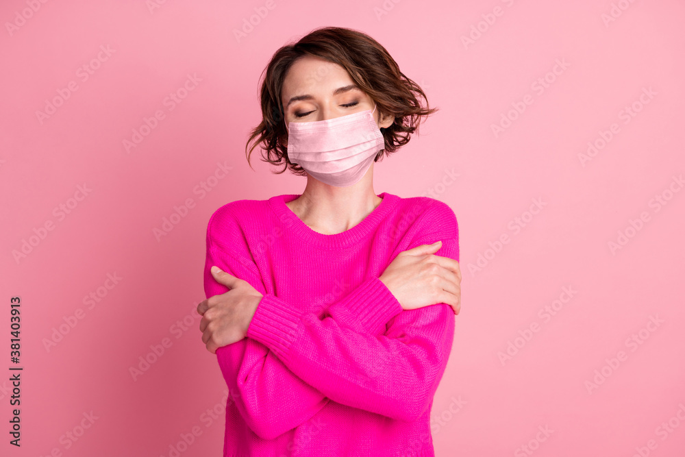 Photo of attractive lady hands hug herself shoulders enjoy joyful soft cloth laundry warmth eyes closed wear casual bright sweater medical mask isolated pink pastel color background Photo of attractive lady hands hug herself shoulders enjoy joyful soft cloth laundry warmth eyes closed wear casual bright sweater medical mask isolated pink pastel color background