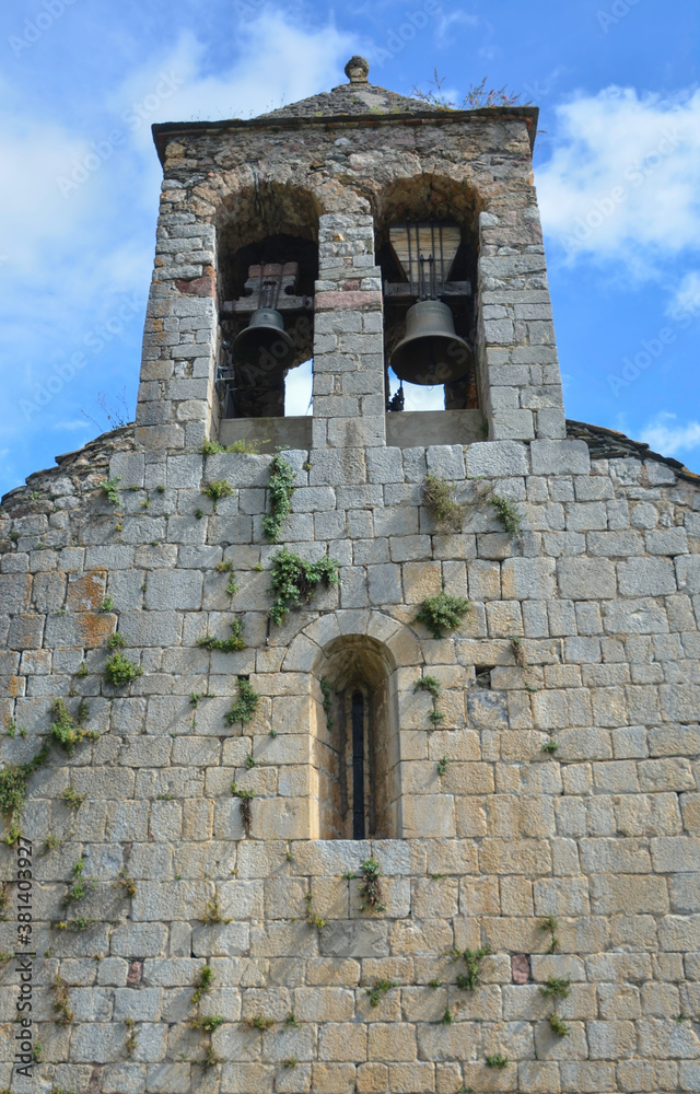 ROCABRUNA, CATALONIA, SPAIN, EUROPE, SEPTEMBER 2020. Bell tower of the 12th century Romanesque church in the medieval town of Rocabruna, at the bottom you can see a horizontal window.