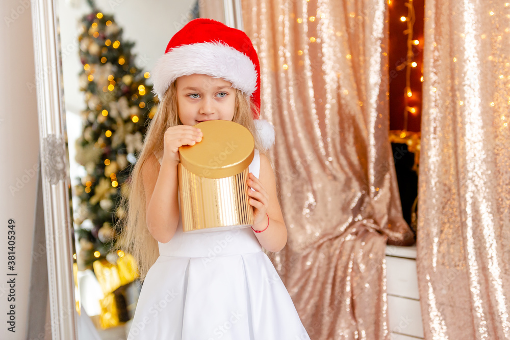 Cute little blonde girl opens a Christmas present. Happy Christmas baby. Cute little blonde girl opens a Christmas present. Happy Christmas baby.