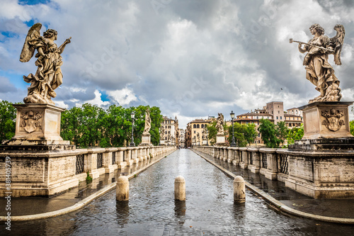 Ancient historical bridge with statues. Ponte Sant Angelo in Rome in Italy. Bad weather with clouds and rain.