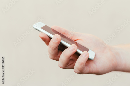 male hands holding a modern phone mock-up for your text message or information content, on the street