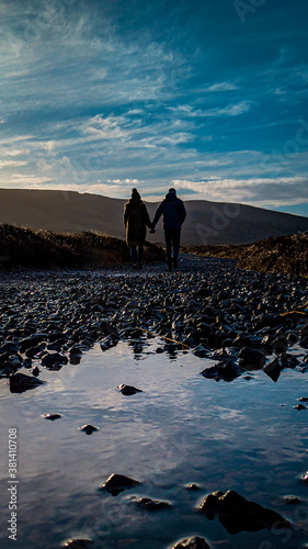 Couple walking away from reflection in water 

