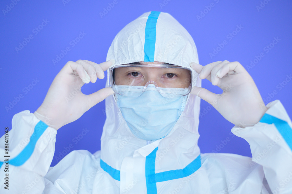 An Asian man is wearing ppe suit on purple background An Asian man is wearing ppe suit on purple background