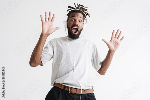 Photo of shocked african american guy in headphones expressing surprise