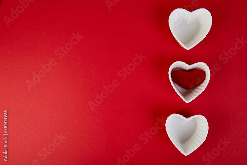 White ceramic hearts with red plush hearts on red background